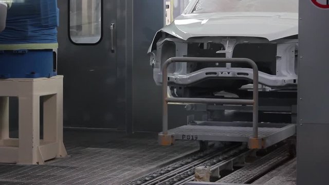  The painted car body moves in the spray booth to the conveyor of the car factory.