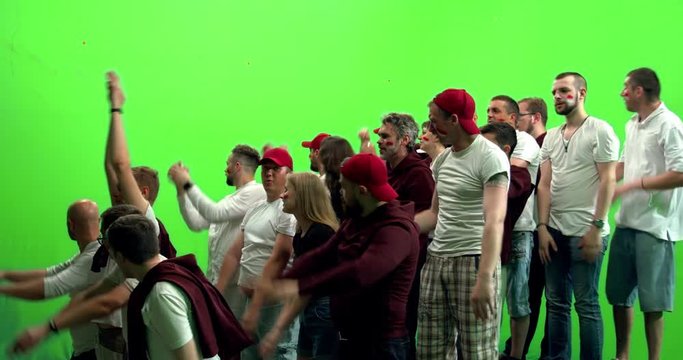 GREEN SCREEN CHROMA KEY 3/4 view group of people fans wearing red clothes doing a wave during a sport event. 4K UHD ProRes 422 HQ