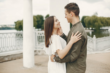 Naklejka premium Cute couple in a city. Lady in a white dress. Boy in a green shirt
