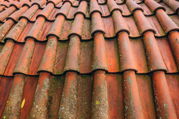 Exterior of brick house with red roof tiles, Prague. Retro red tile roof of old house