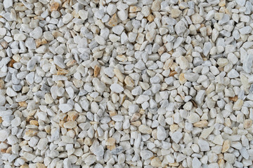 White gravel texture. Stone pebbles white color poured in a pile close-up.