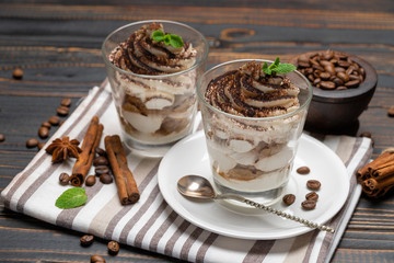 Classic tiramisu dessert in a glass on wooden background