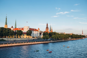Naklejka premium Panoramic view of the Old Town from the cable-stayed bridge to the Daugava embankment at sunset. Riga, Latvia. Riga Castle with the Riga Cathedral in front of. St. Peter's Church in the background.
