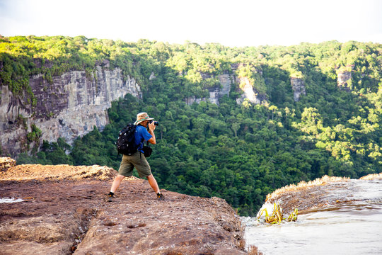 Tourists taking pictures of the river East Berbice front of the Kaieteur falls, Guyana. The waterfall is one of the most beautiful and majestic waterfalls in the world with a height of 221 meters. Wor