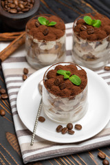 Classic tiramisu dessert in a glass on wooden background