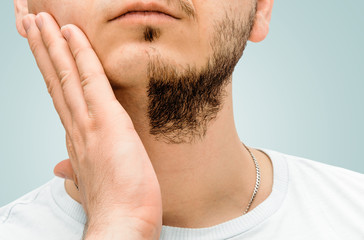 Naklejka premium Before and after facial hair of a man on a blue, pastel background. The concept of personal hygiene in a man. A man with a beard and no beard. Shaving and taking care of facial hair.