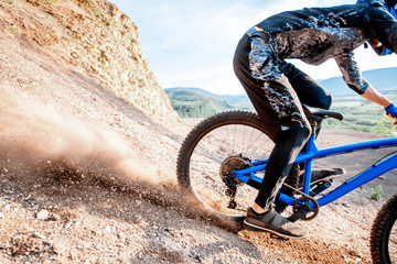 Professional well-equiped cyclist riding down on the rocky mountains. Concept of a freeride and off...