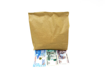 Closed paper bag with food from the store and money