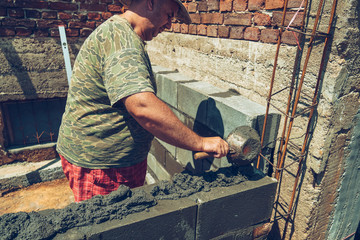 Worker on construction site, building walls