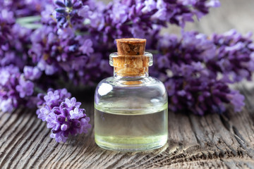 A bottle of lavender essential oil with fresh lavender