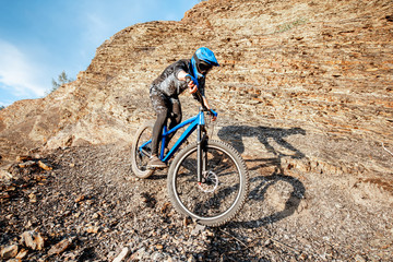 Professional well-equipped cyclist riding bicycle on the rocky mountains. Concept of a freeride and...