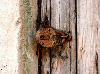 Old lock on the door. lock on the door of an old rural home. Real country style. close-up. focus on the castle. Old antique lock on old wooden doors in need of repair or replacement. 