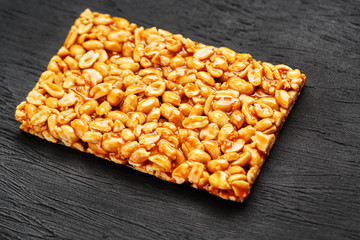 Golden boletus kozinaki from roasted peanut beans energy bars. Black textural background, top view