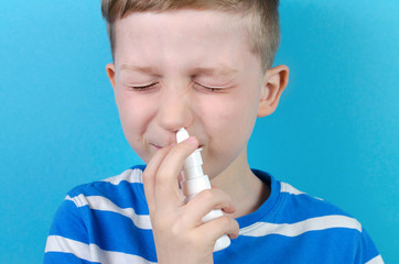 little boy with nasal spray, blue background