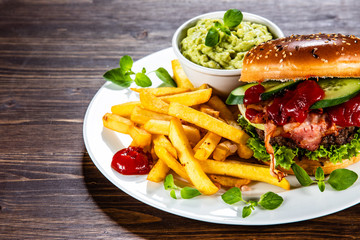 Tasty burger with chips served white plate