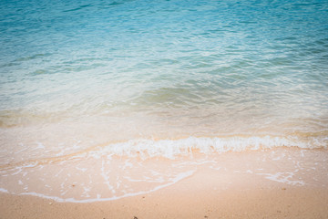 Fototapeta na wymiar Soft wave of blue ocean on sandy beach. Background