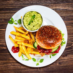 Tasty burger with chips served white plate