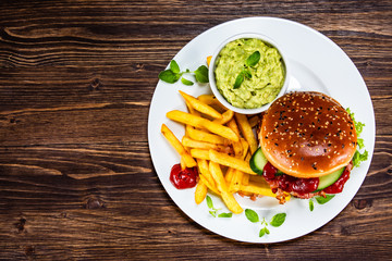 Tasty burger with chips served white plate