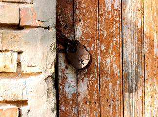 Old lock on the door. lock on the door of an old rural home. Real country style. close-up. focus on the castle. Old antique lock on old wooden doors in need of repair or replacement.
