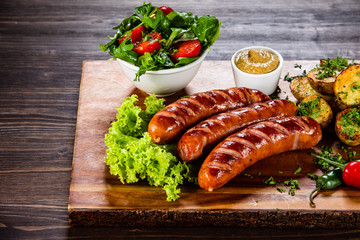 Grilled sausages and vegetables on cutting board