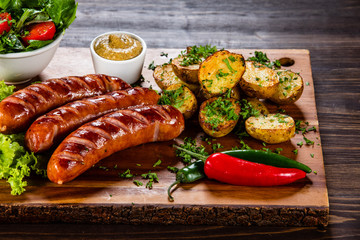 Grilled sausages and vegetables on cutting board
