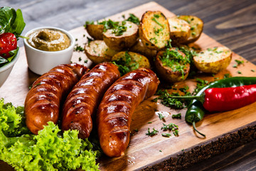 Grilled sausages and vegetables on cutting board