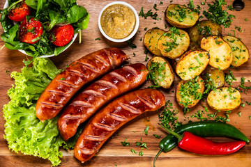 Grilled sausages and vegetables on cutting board