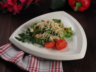 Salad with grated cheese and vegetables in a triangular plate