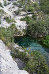 Lago de agua azul y cristalina entre montañas de caliza.