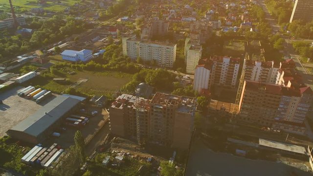 Aerial flight over the streets of new built suburbs and plated with young trees, on sunny day. 4K.