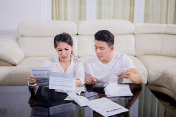 Fototapeta premium Young couple looks stressed with their high expenses