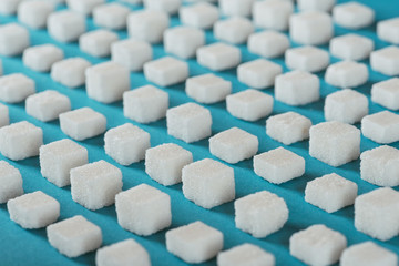 white sugar cubes arranged in rows on blue surface