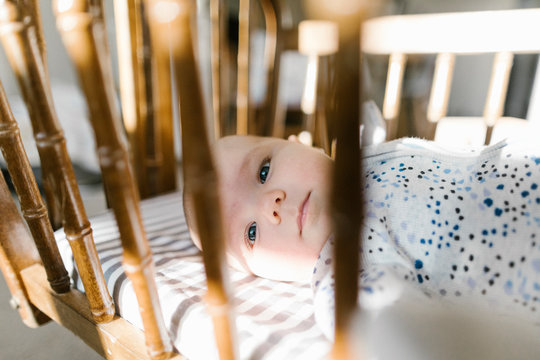 Side view of baby laying in crib.