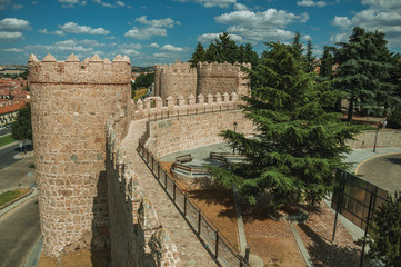 Fototapeta na wymiar Pathway over old thick wall with large towers in Avila