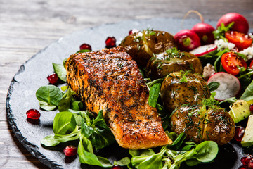 Grilled salmon, baked potatoes and vegetable salad