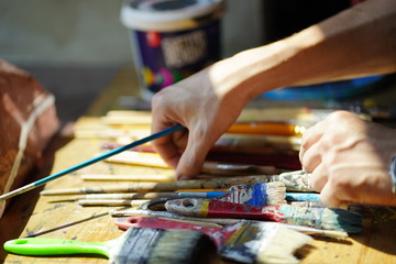 Artist brushes lie on a wooden board. The working environment of the artist for the background.