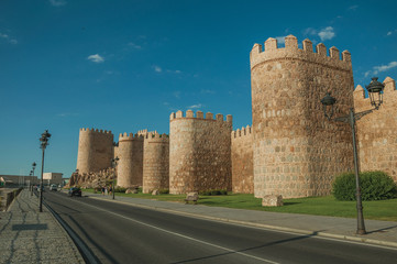 Street and light posts beside towers in the wall around Avila