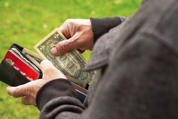 Fototapeta premium Businessman Person holding an wallet in the hands of an man take money out of pocket.
