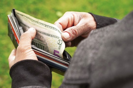 Businessman Person holding an wallet in the hands of an man take money out of pocket.