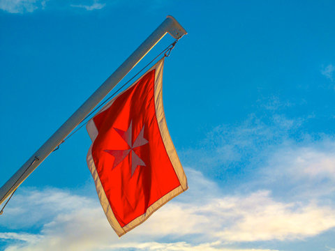 Red flag with Maltese cross. The flag of knights used on a cruise ship ship that is attributed to Malta.