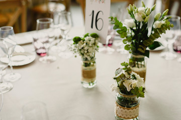 Centerpieces in a wedding hall, floral decorations photographed during the day.