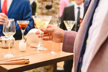 People in a cocktail drinking alcohol from their glasses and having fun at the party.