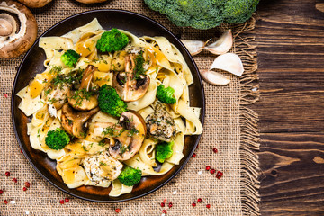 Pasta with chicken and champignon on wooden background