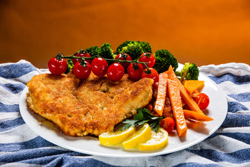 Fried pork chop, French fries and vegetable salad