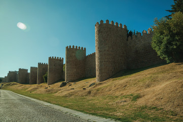 Sunbeam above the large city wall and green lawn at Avila
