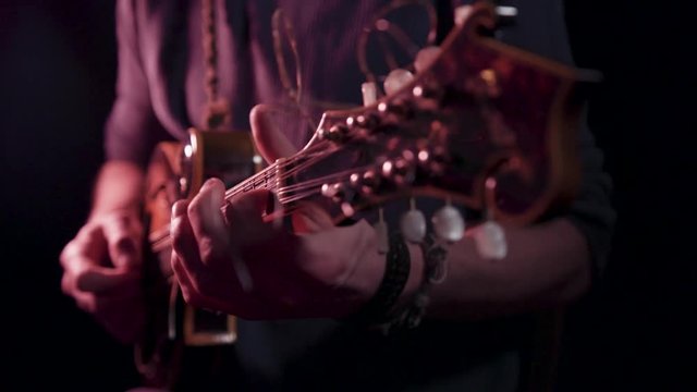 Folk musician playing mandolin, close up