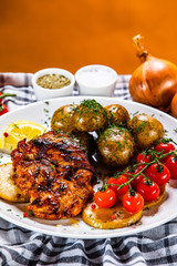 Grilled chicken fillet and vegetables on white plate