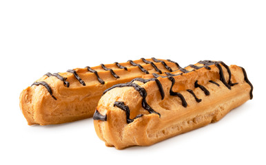 Two eclairs drenched in chocolate close-up on a white. Isolated.