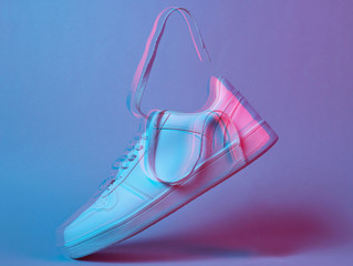 Fashionable white sneakers with flying laces, glitch effect, retro futurism red blue neon light,...