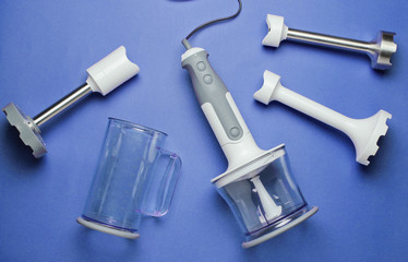 Electric hand blender with nozzles on blue background. Top view, Flat lay